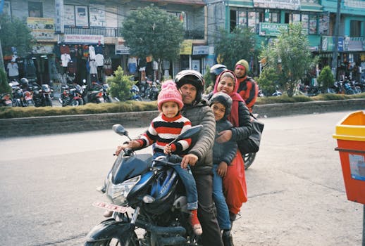 Family of four on motorcycle in a bustling urban street, showcasing daily life.