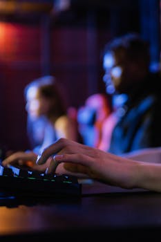 Close-up of hands typing on a keyboard during an intense gaming session in a dimly lit room.