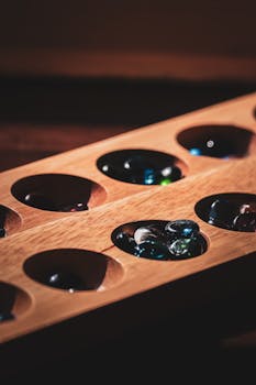 Detailed shot of a Mancala board with colorful marbles, highlighting the game's aesthetic allure.